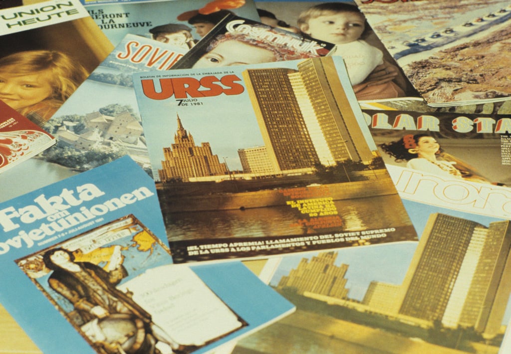 A collection of colorful Soviet-era magazines in various languages, spread out, featuring images of children, cityscapes, and Soviet landmarks on their covers.