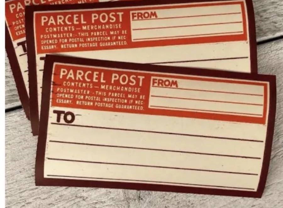 Two vintage-style brown and cream parcel post labels with “TO” and “FROM” sections and blank lines, placed on a light wooden surface.