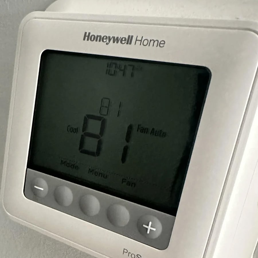 A Honeywell Home thermostat displays a temperature of 81 degrees with the “Cool” and “Fan Auto” settings active. The time shown is 10:47. Four control buttons are visible below the screen.