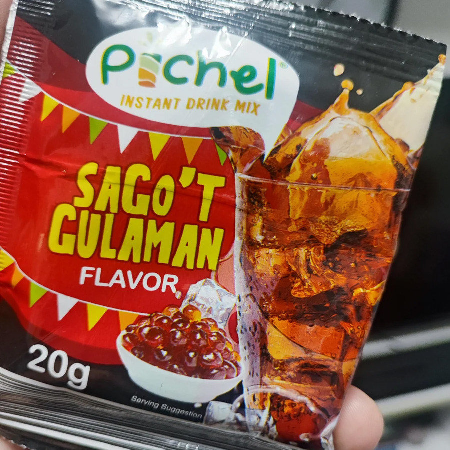 A hand holds a 20g sachet of “Pichel Instant Drink Mix” in Sago’t Gulaman flavor, showing a glass of iced drink and sago pearls on the packaging.