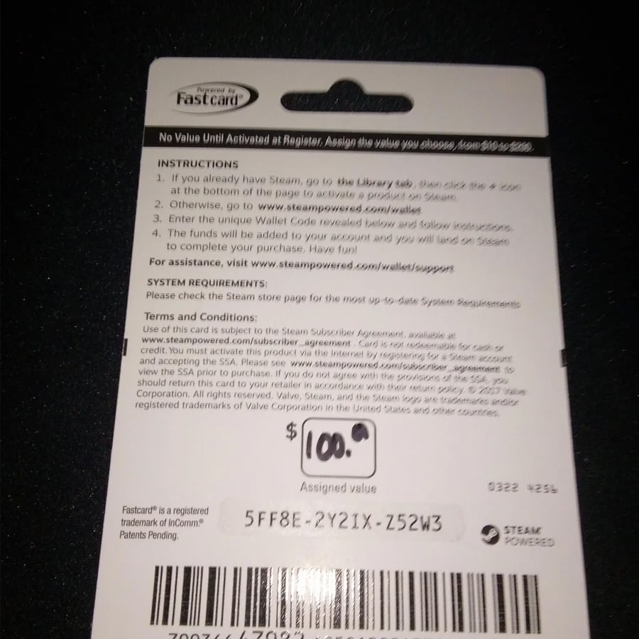 A Steam gift card showing a value of $100. The card displays instructions, terms, and a 15-character code: 5FF8E-2Y2IX-Z52W3. The card states it has no value until activated at the register.