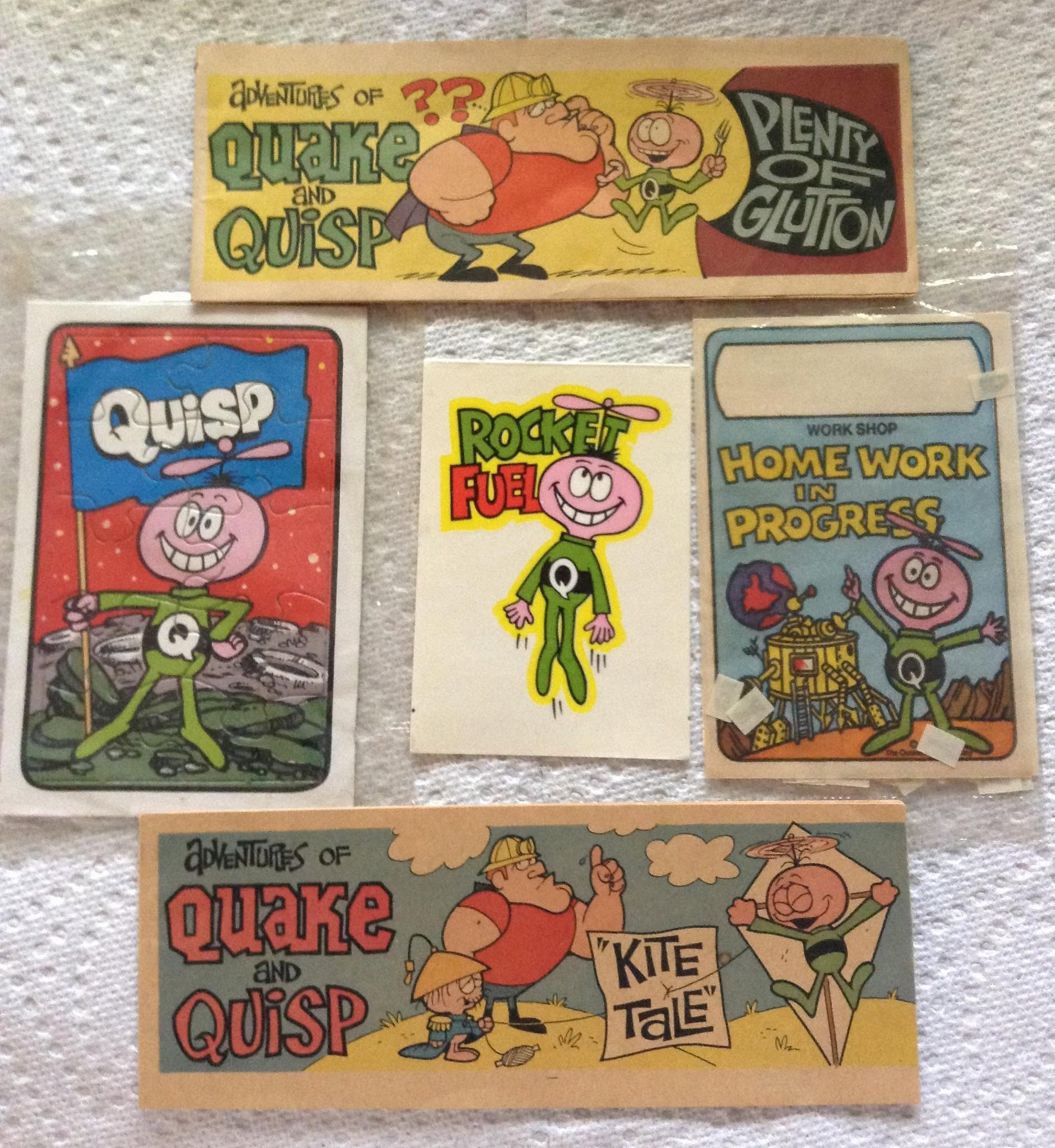 Five colorful vintage cartoon cards featuring Quisp, Quake, and humorous scenes; phrases include “Plenty of Gluton,” “Rocket Fuel,” and “Homework in Progress.” Characters have big heads and playful expressions.