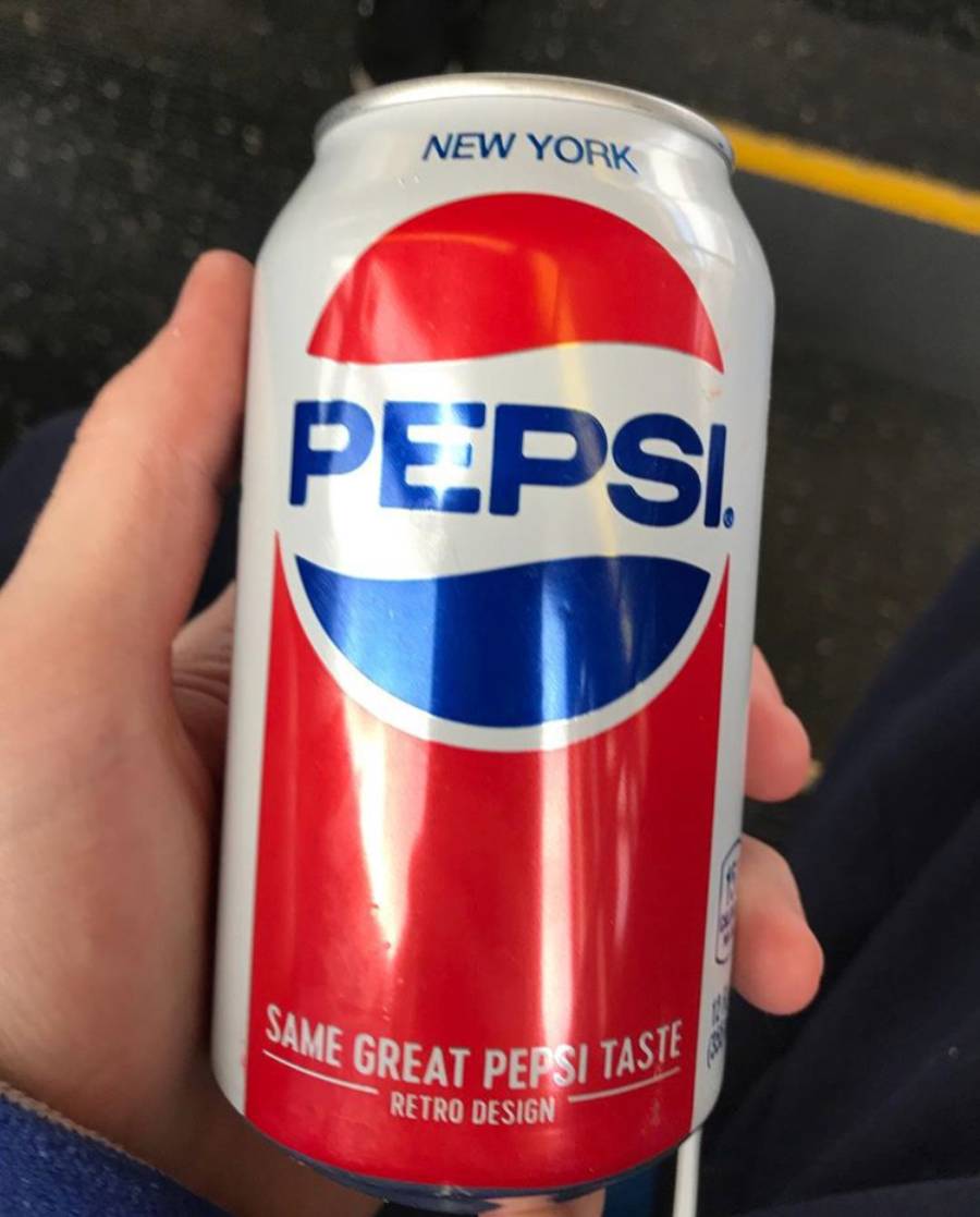 A hand holds a Pepsi can with a retro red, white, and blue design. The can reads “NEW YORK,” “PEPSI,” and “SAME GREAT PEPSI TASTE RETRO DESIGN.”