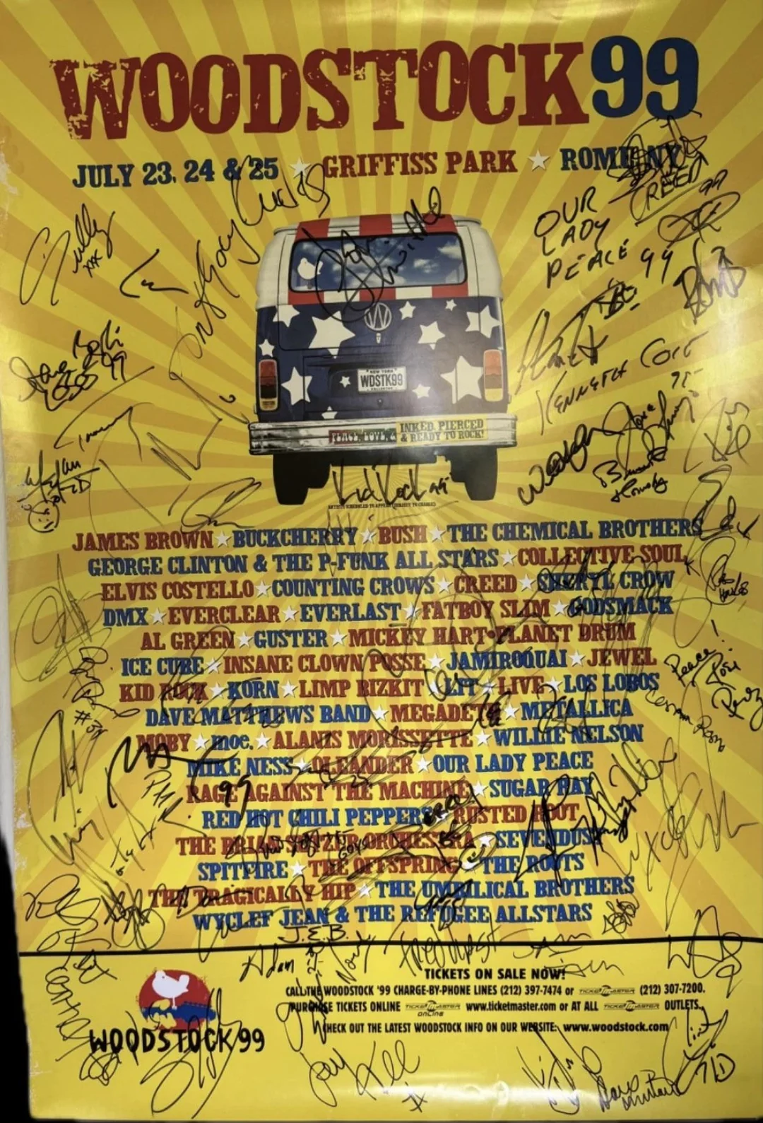 Yellow poster for Woodstock 99 featuring a van with stars and stripes. It lists bands and event info for July 23-25, 1999, and is covered in black marker signatures.
