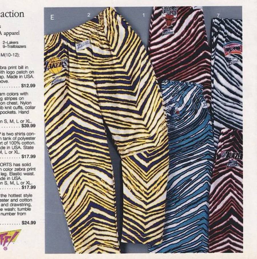 Three pairs of NBA-themed zebra print pants in yellow, red, and blue, each featuring a different team logo: Lakers, Bulls, and Hornets. The pants are displayed overlapping on a catalog page.