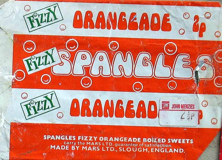 Vintage Spangles Fizzy Orangeade sweets wrapper, orange and white with bubble graphics, green “FIZZY” labels, and text showing price as 2p. Includes price sticker and manufacturer details from Mars Ltd., England.