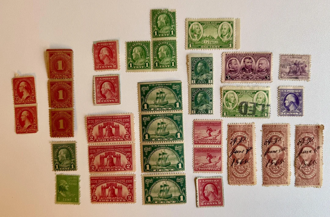 A collection of vintage U.S. postage stamps in various colors, denominations, and groupings is arranged neatly on a white background.