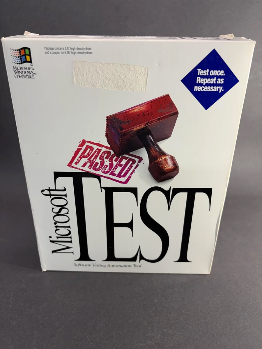 Microsoft Test software box with a red “PASSED” stamp graphic, a blue sticker that reads “Test once. Repeat as necessary,” and the old Microsoft Windows logo in the top left corner.
