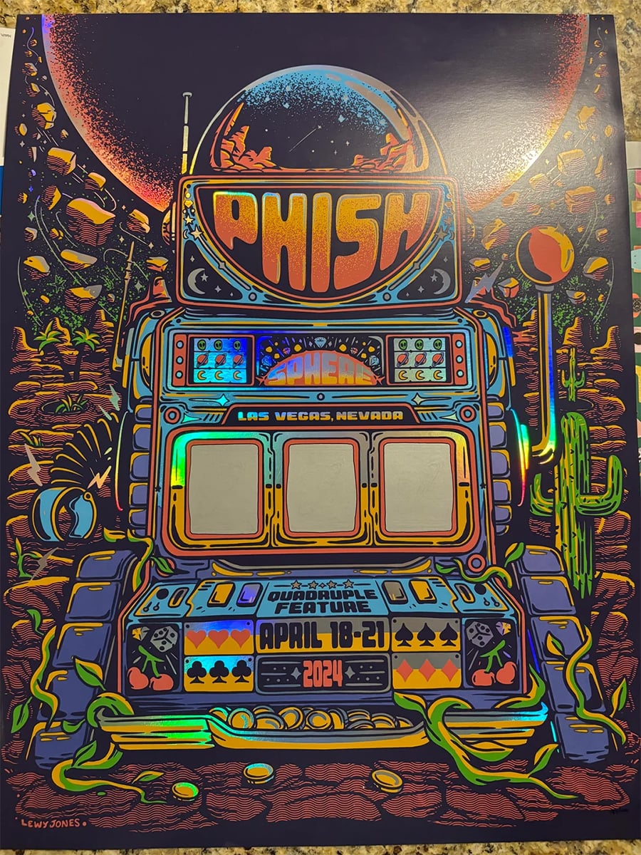 Colorful concert poster for Phish, featuring a slot machine with desert scenery, cacti, cards, and “Las Vegas, Nevada, April 18-21, 2024” text. Retro, vibrant artwork with neon and metallic effects.