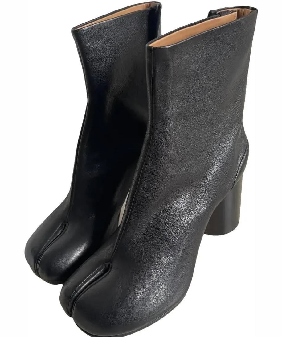 A pair of black leather ankle boots with a split toe design and chunky heels, viewed from a slightly angled perspective.