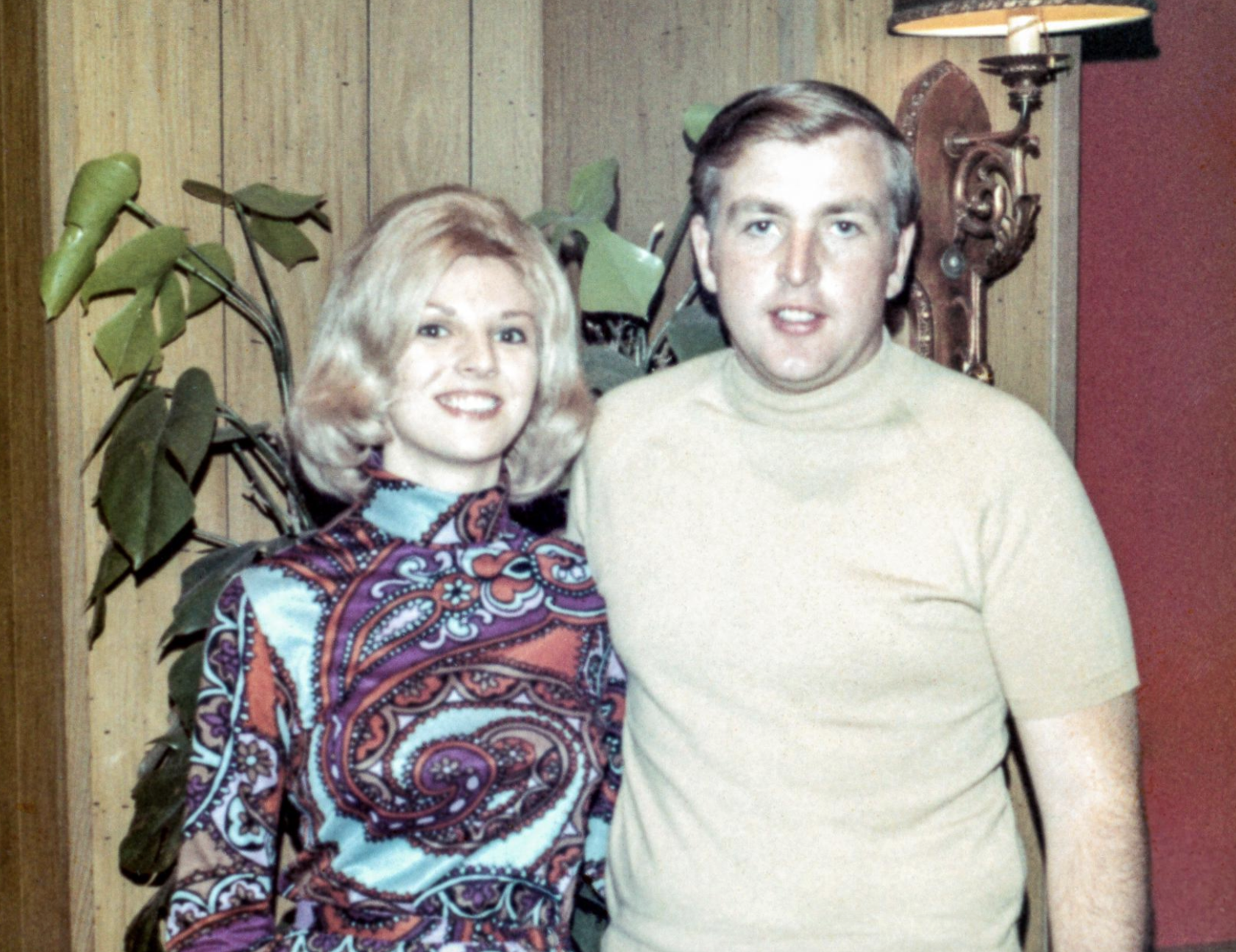 A man and a woman posing for a photo indoors.