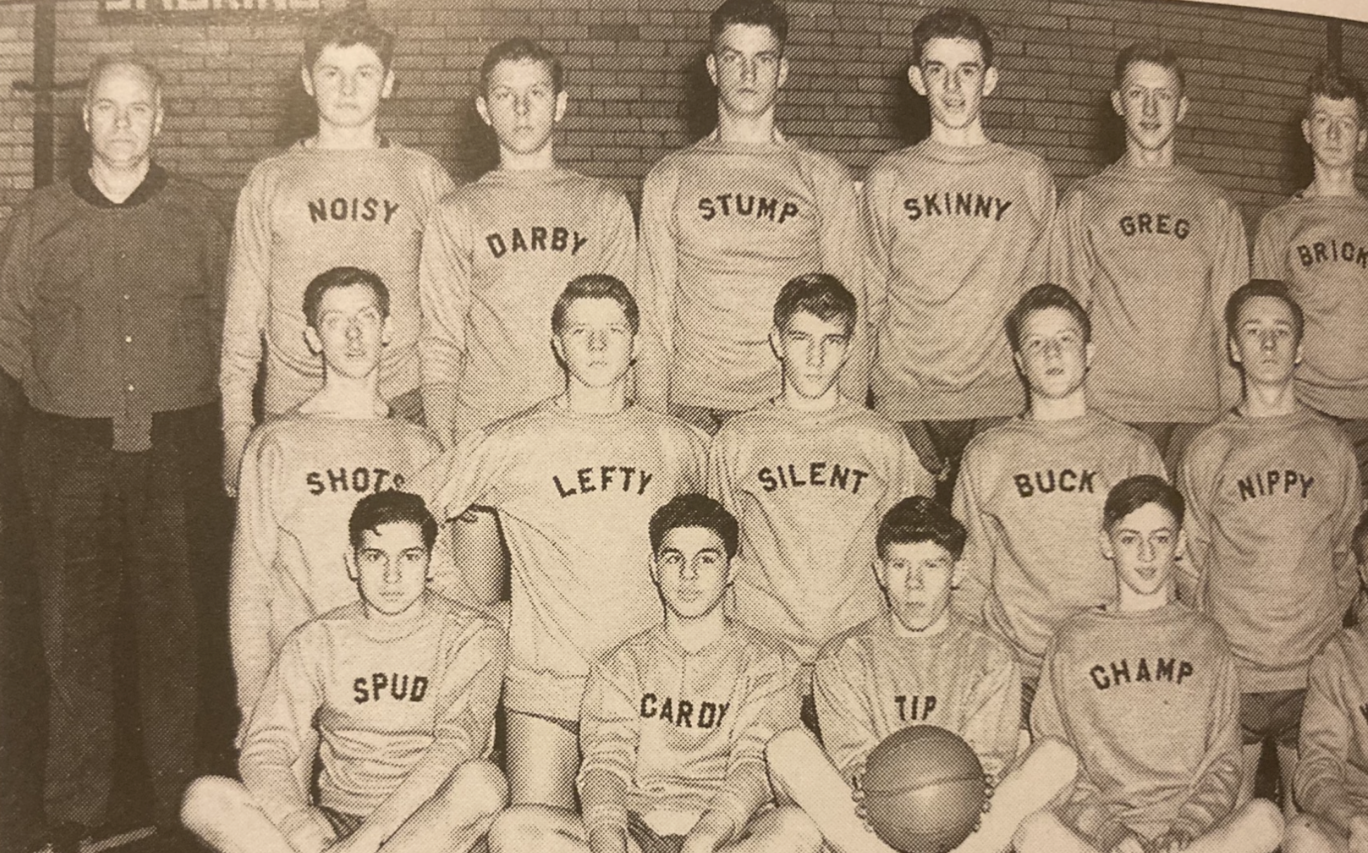 A vintage black-and-white team photo of a coach and fifteen basketball players, each wearing a jersey printed with a unique nickname.