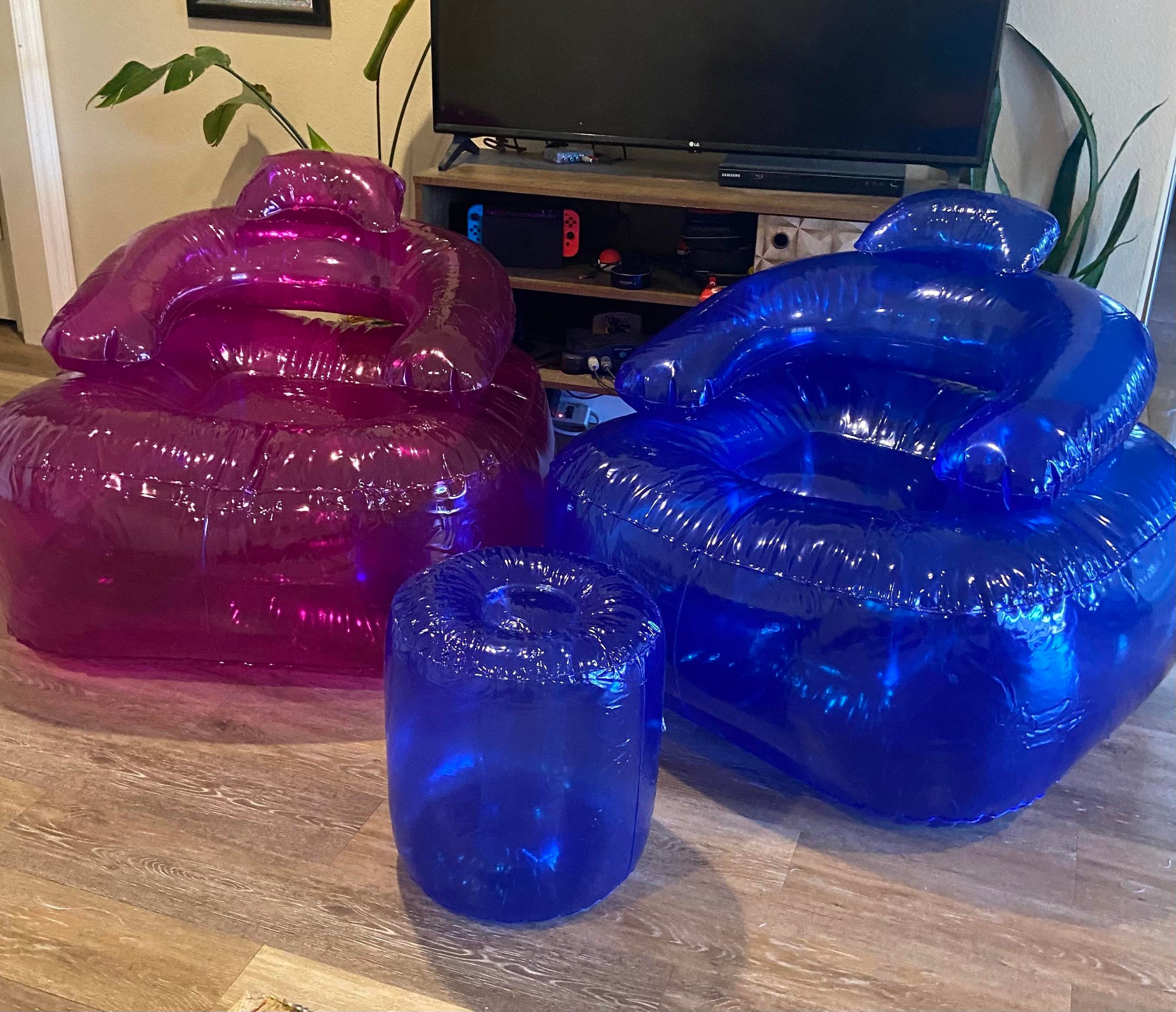 A purple inflatable chair, a blue inflatable chair, and a matching blue inflatable ottoman on a wooden floor.