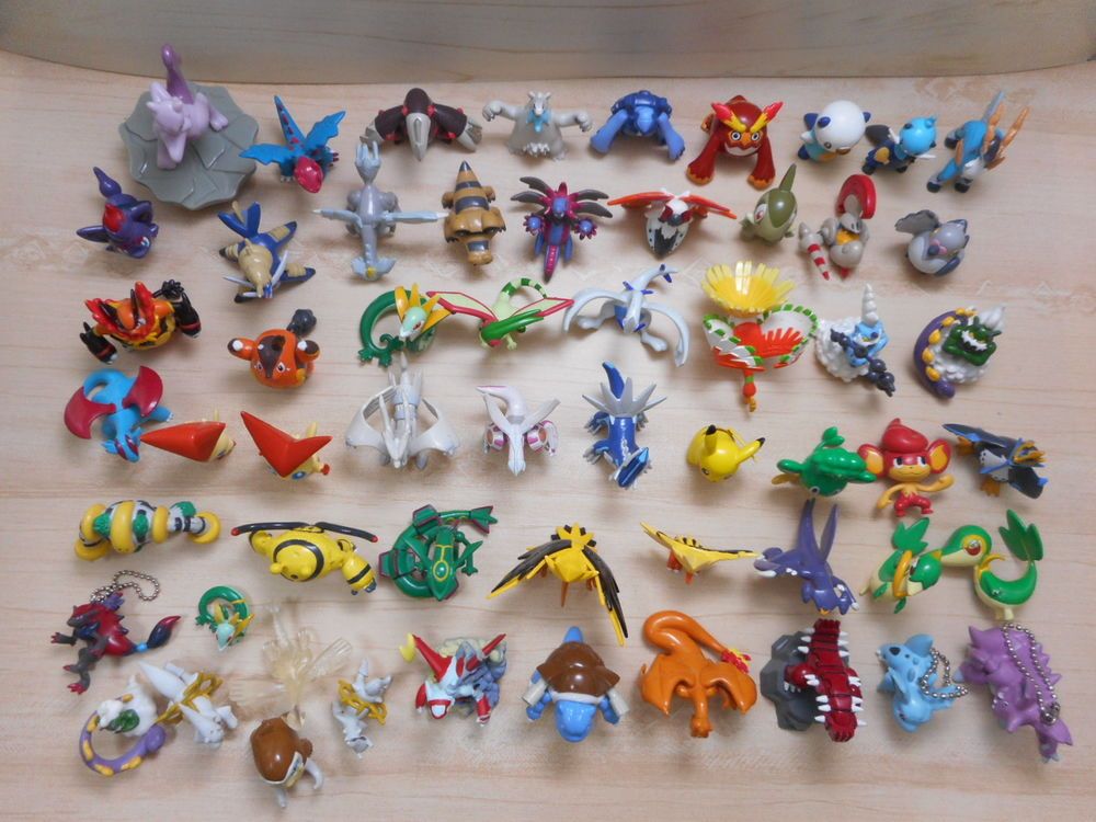 A collection of small plastic Pokémon figurines arranged on a wooden surface.