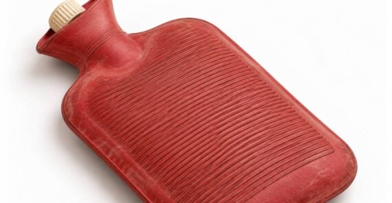 Red rubber hot water bottle with a cream-colored screw top.