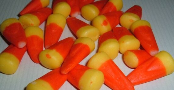 A pile of orange, yellow, and white candy corn pieces.