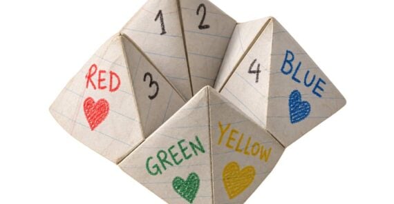 A paper fortune teller decorated with handwritten colors, numbers, and hearts.