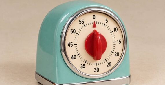 A mint green analog kitchen timer with a red central dial set to zero.