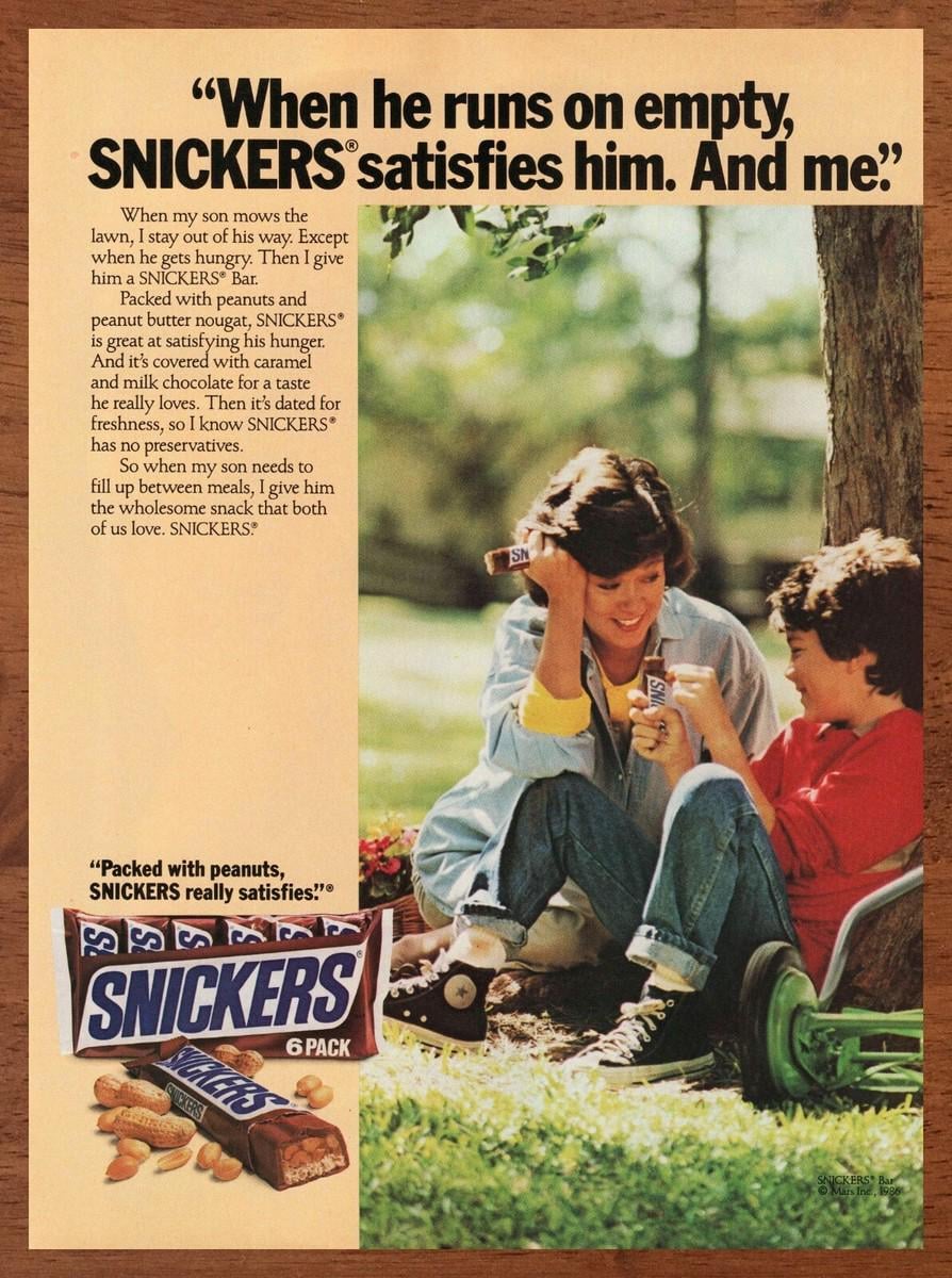 1986 Snickers advertisement featuring a mother and son sharing a candy bar outdoors, with promotional text and an image of a six-pack of Snickers bars.
