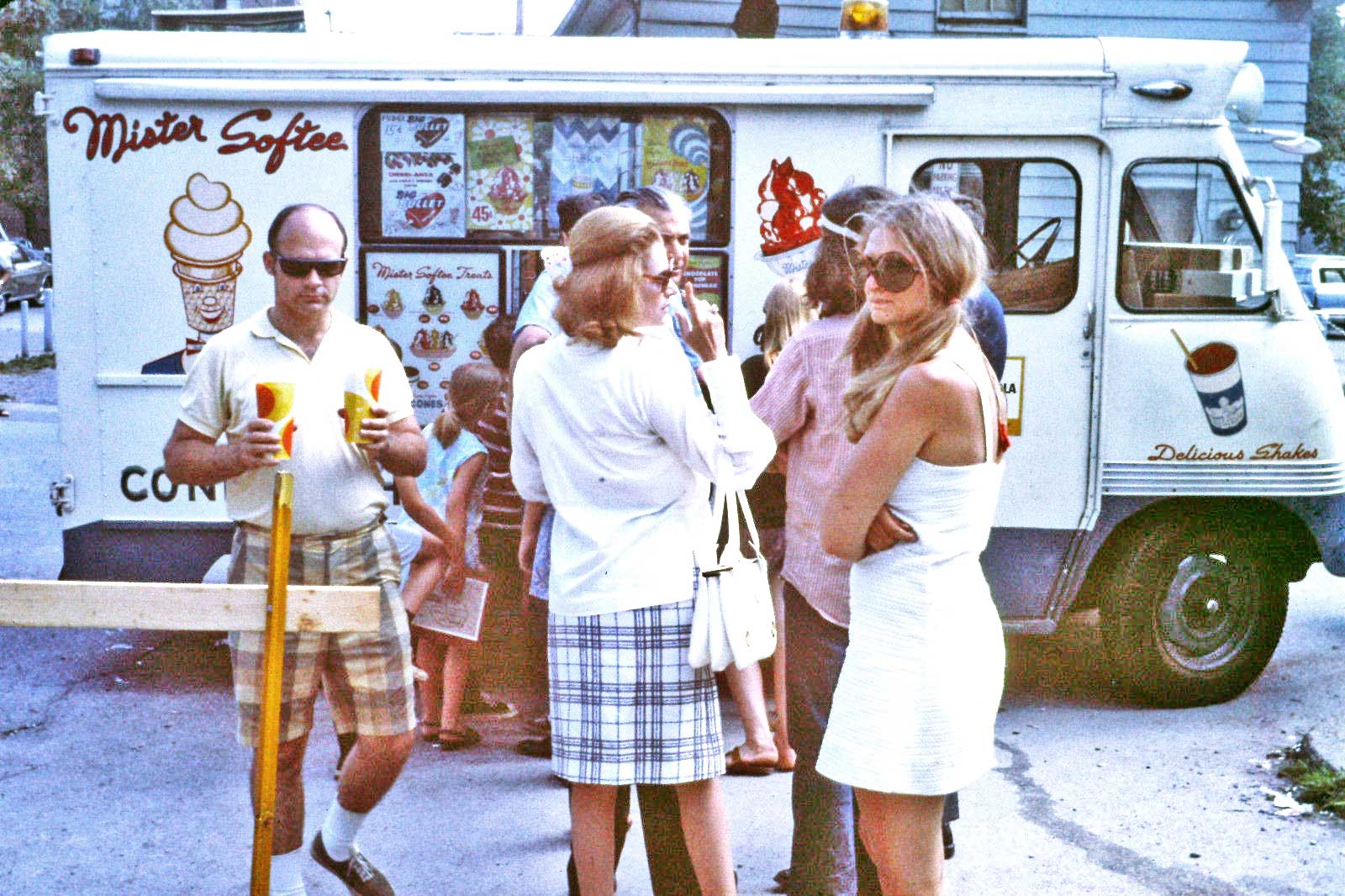 A line of people standing in front of a Mister Softee ice cream truck.