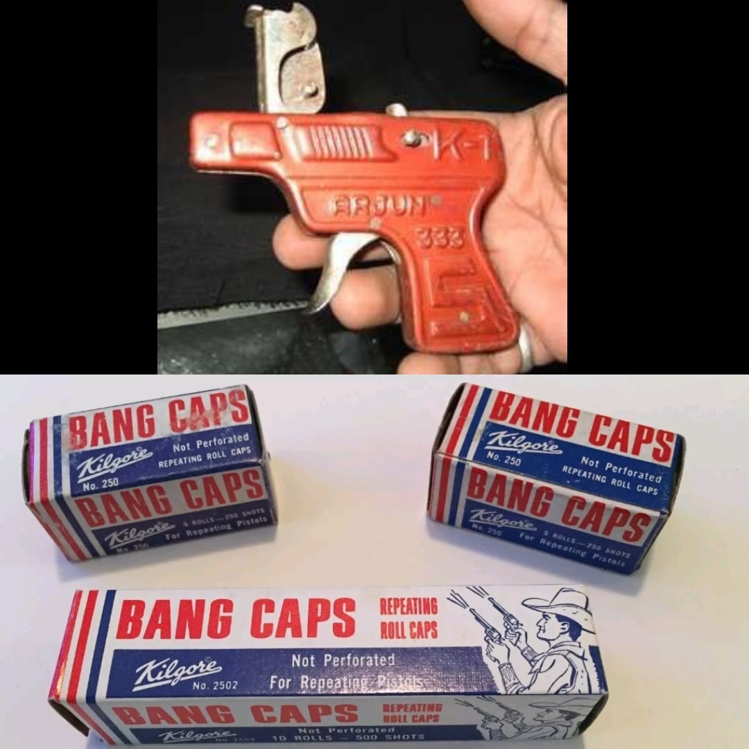 A red toy cap gun held in a hand, positioned above three boxes of Kilgore brand repeating roll caps.