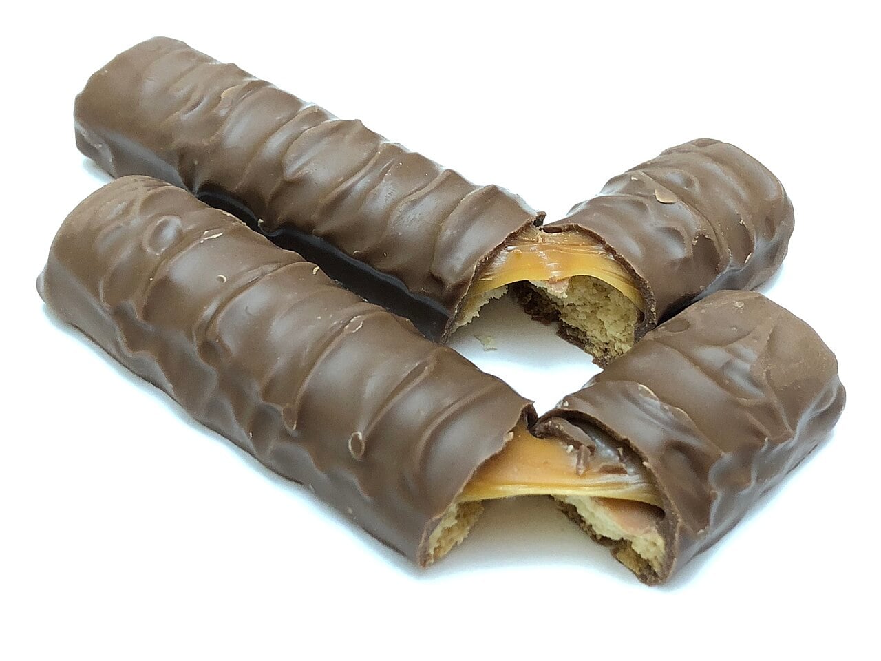 Two chocolate-covered candy bars broken in half to reveal a caramel and cookie center.