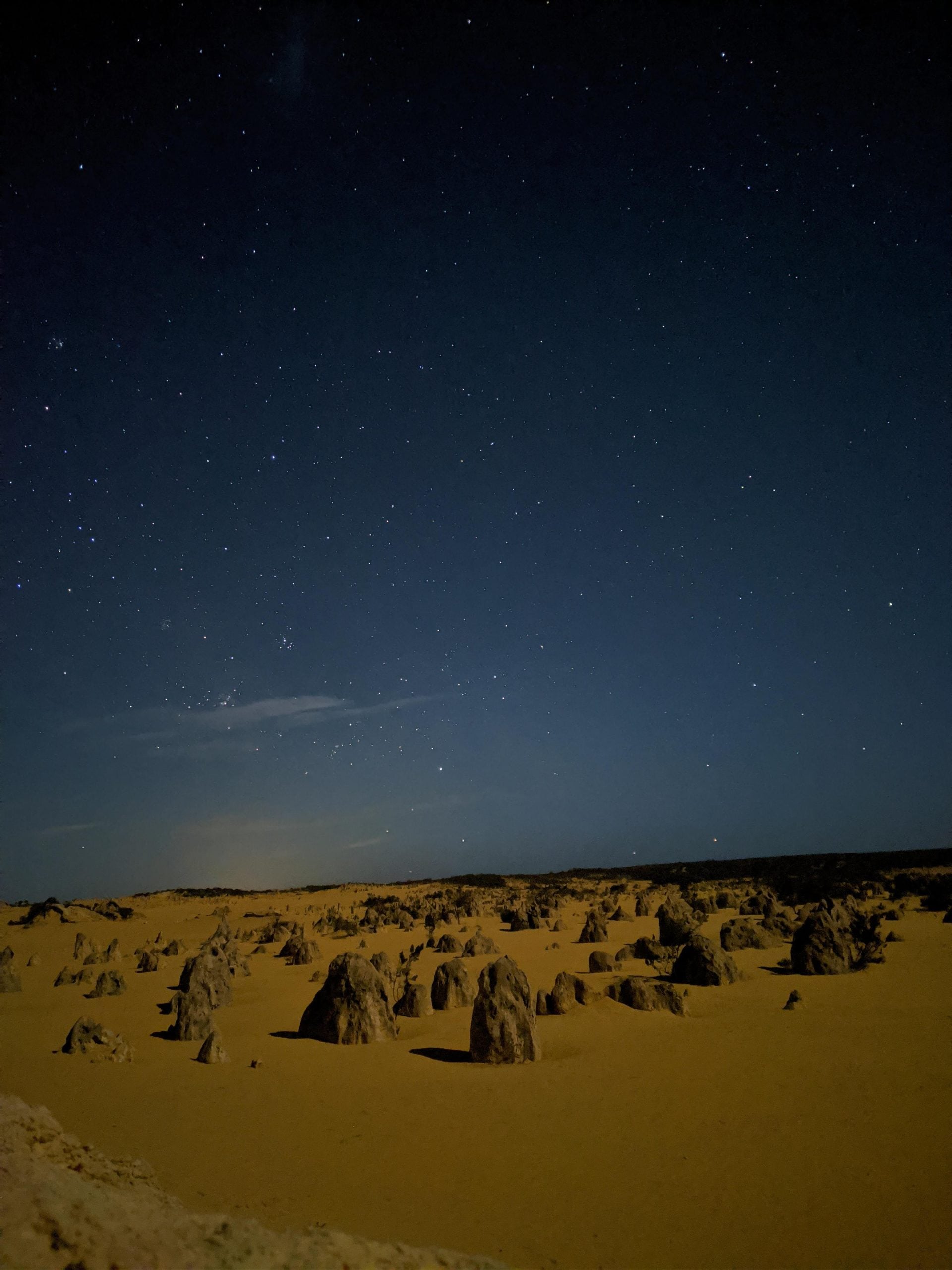 The Pinnacles desert at night under a clear, starry sky.