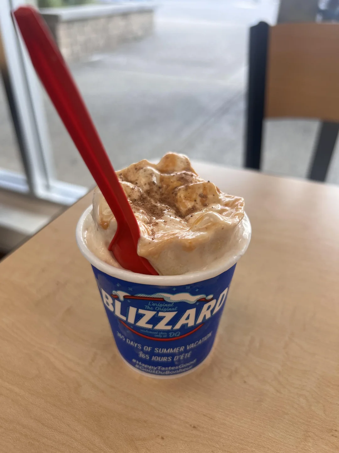 A Dairy Queen Blizzard in a blue cup with a red spoon inserted into the top.