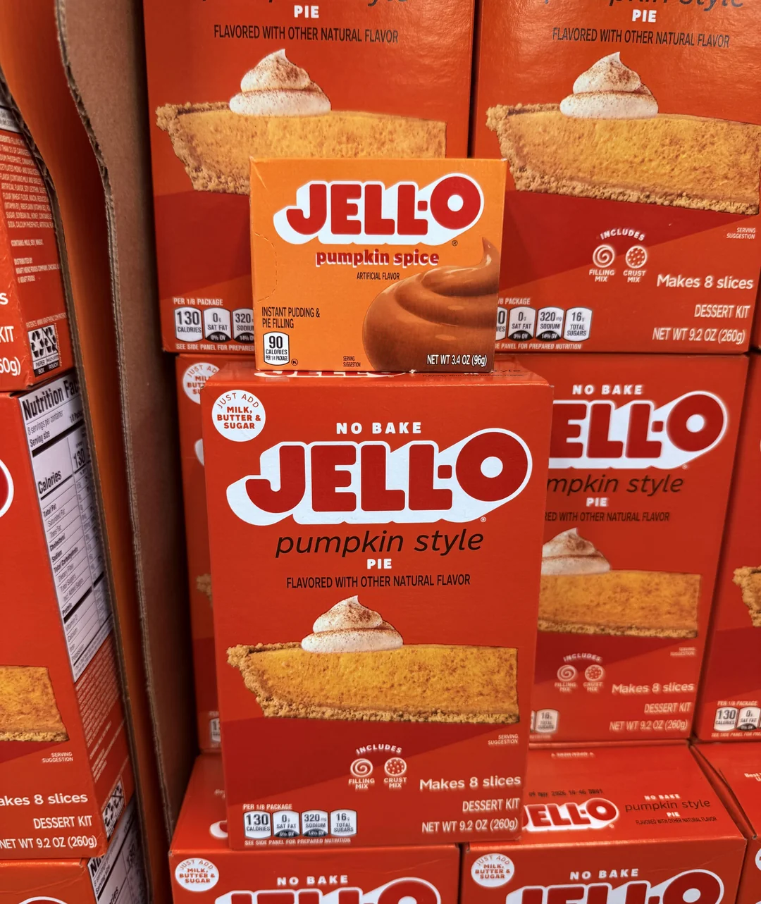 Boxes of Jell-O pumpkin spice pudding mix and no-bake pumpkin style pie dessert kits displayed on a store shelf.