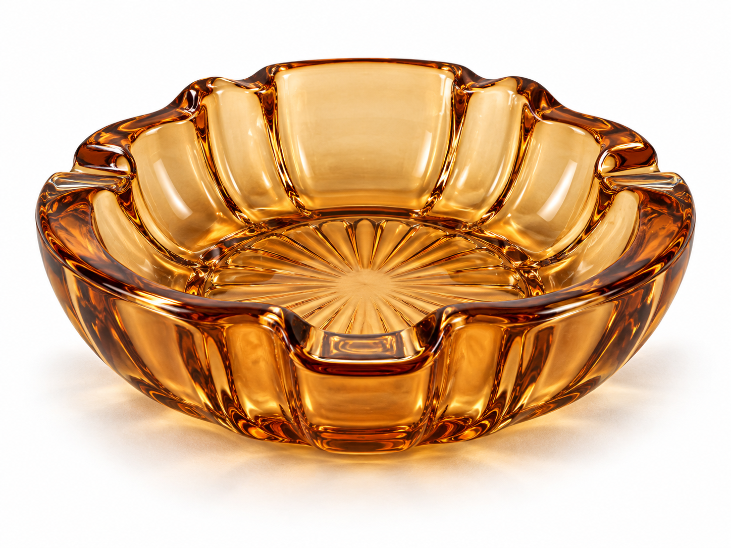 Amber glass ashtray with a scalloped edge and a starburst pattern at the base.
