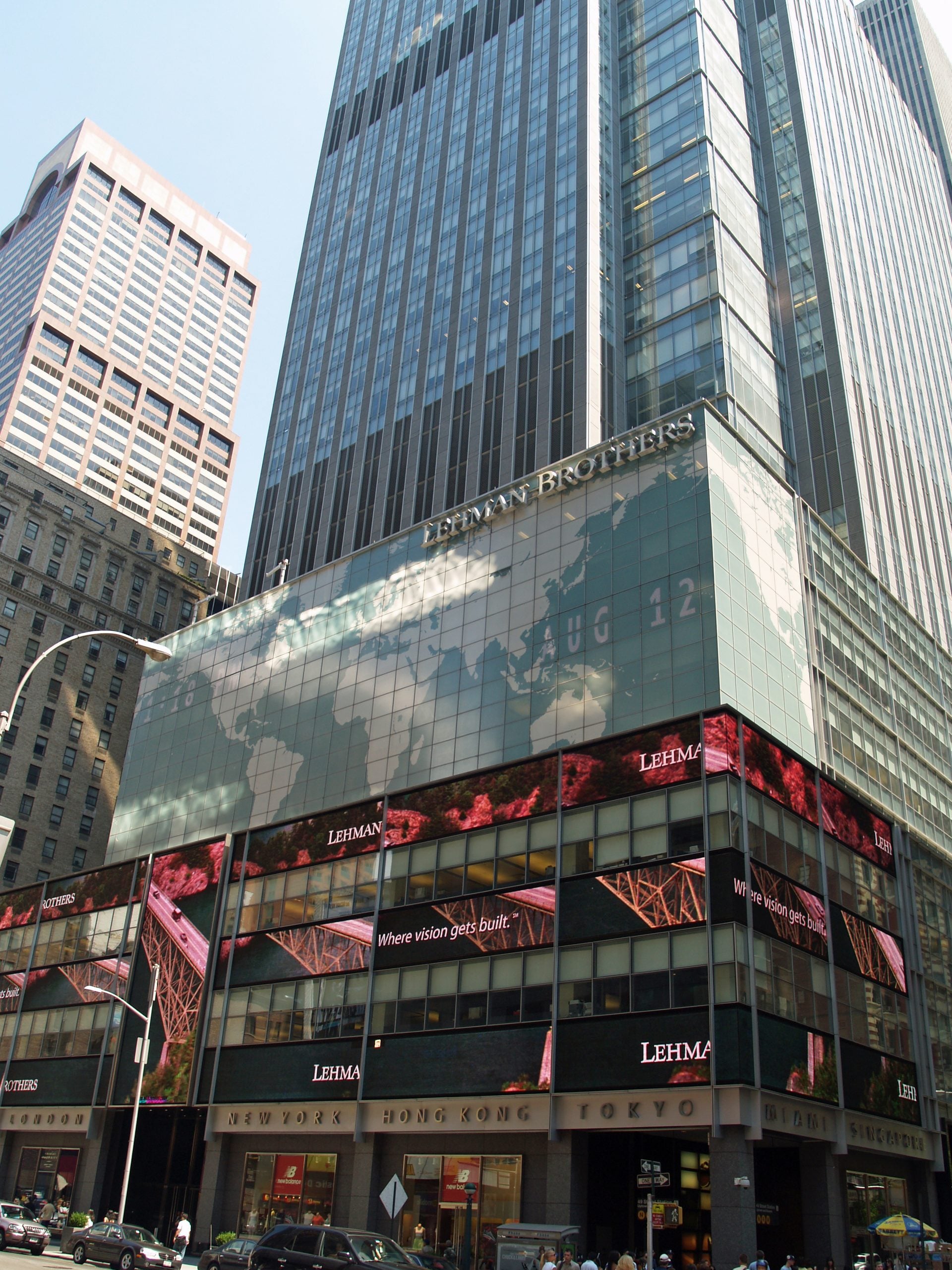 The Lehman Brothers headquarters building in New York City, featuring a large facade display showing a world map and the text “Where vision gets built.”
