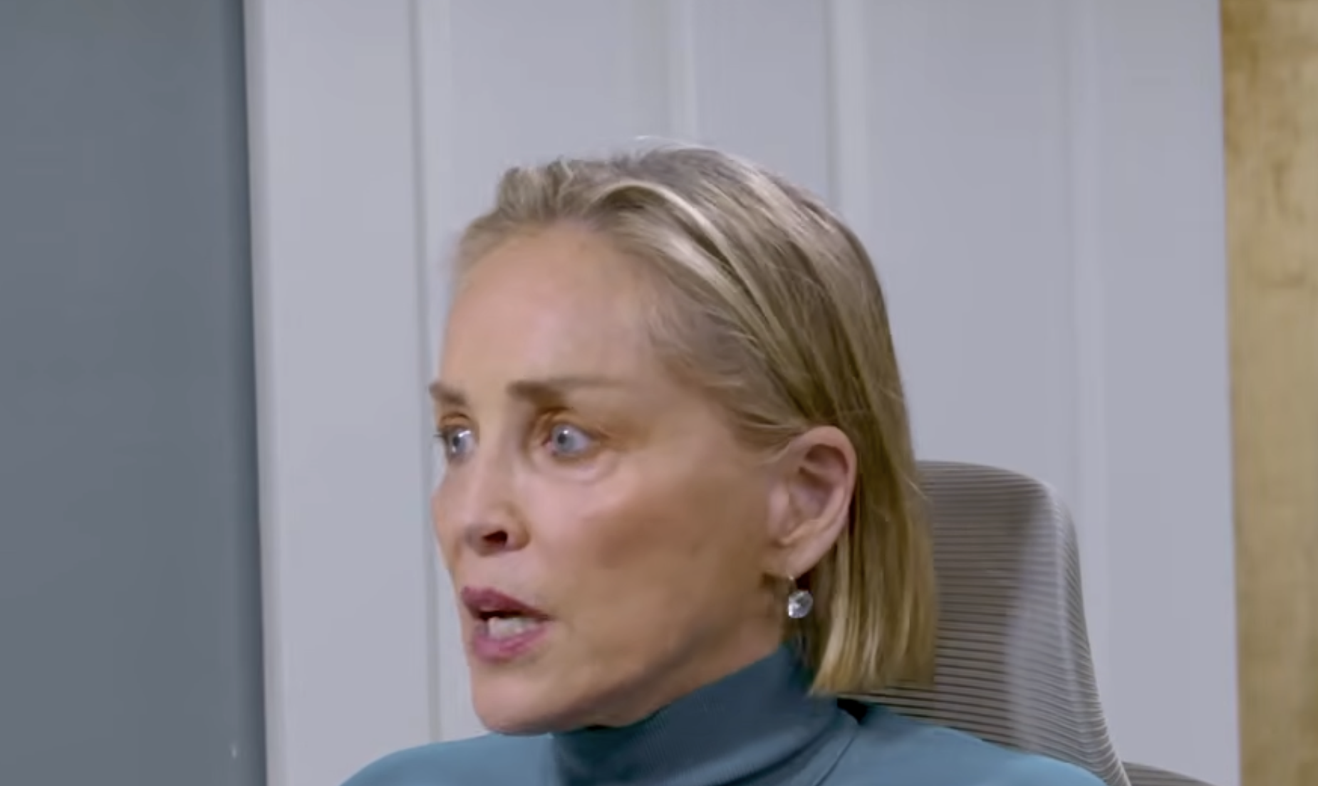 Sharon Stone speaking while seated in an office chair.
