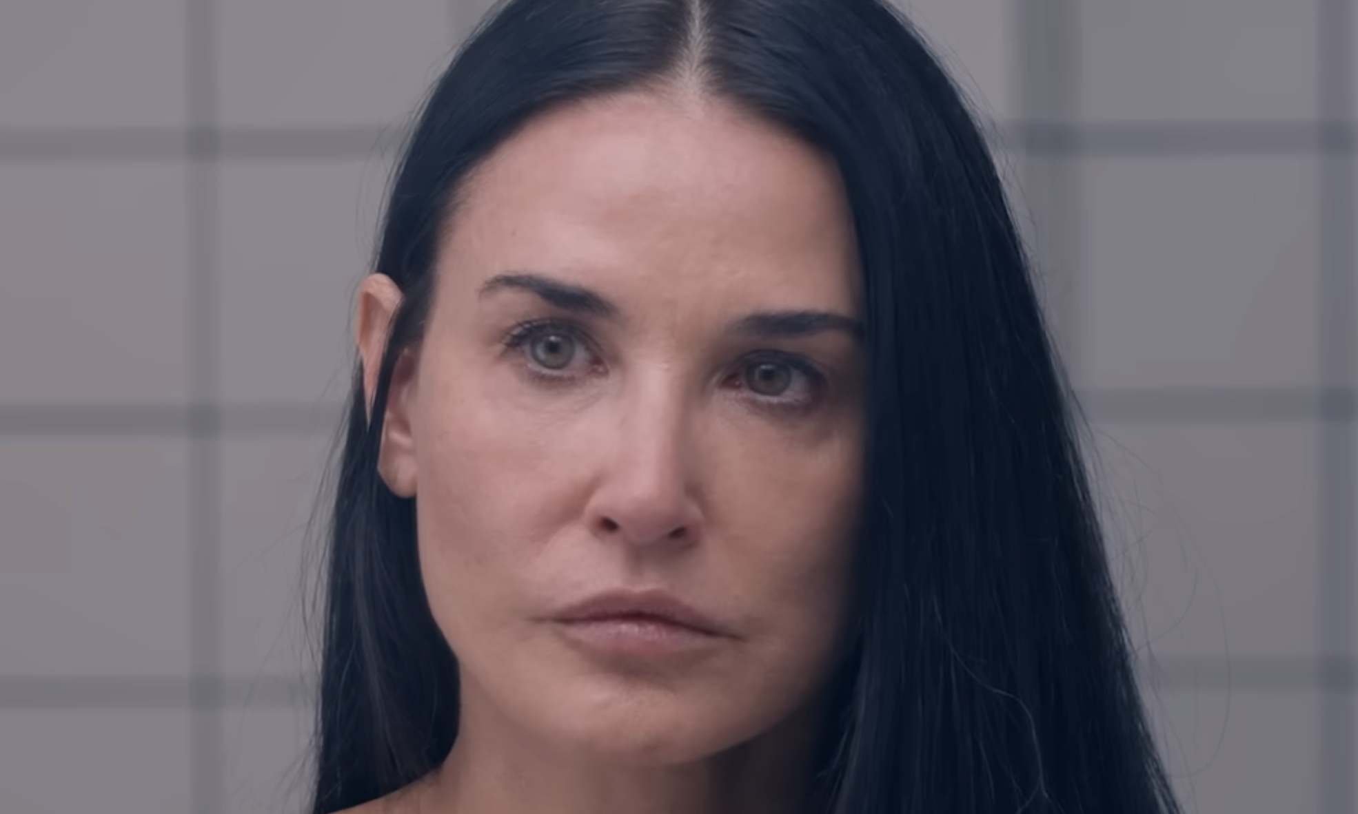 Close-up portrait of actress Demi Moore looking directly at the camera with a neutral expression.