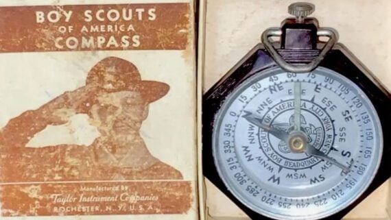 A vintage Boy Scouts of America compass in its original cardboard box.