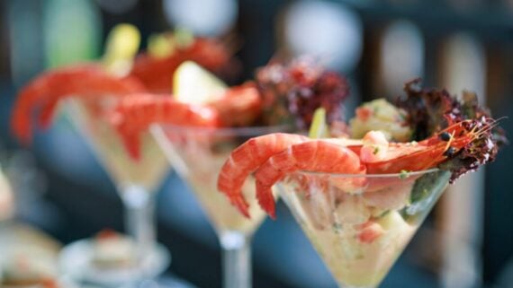 Three shrimp cocktails served in martini glasses.