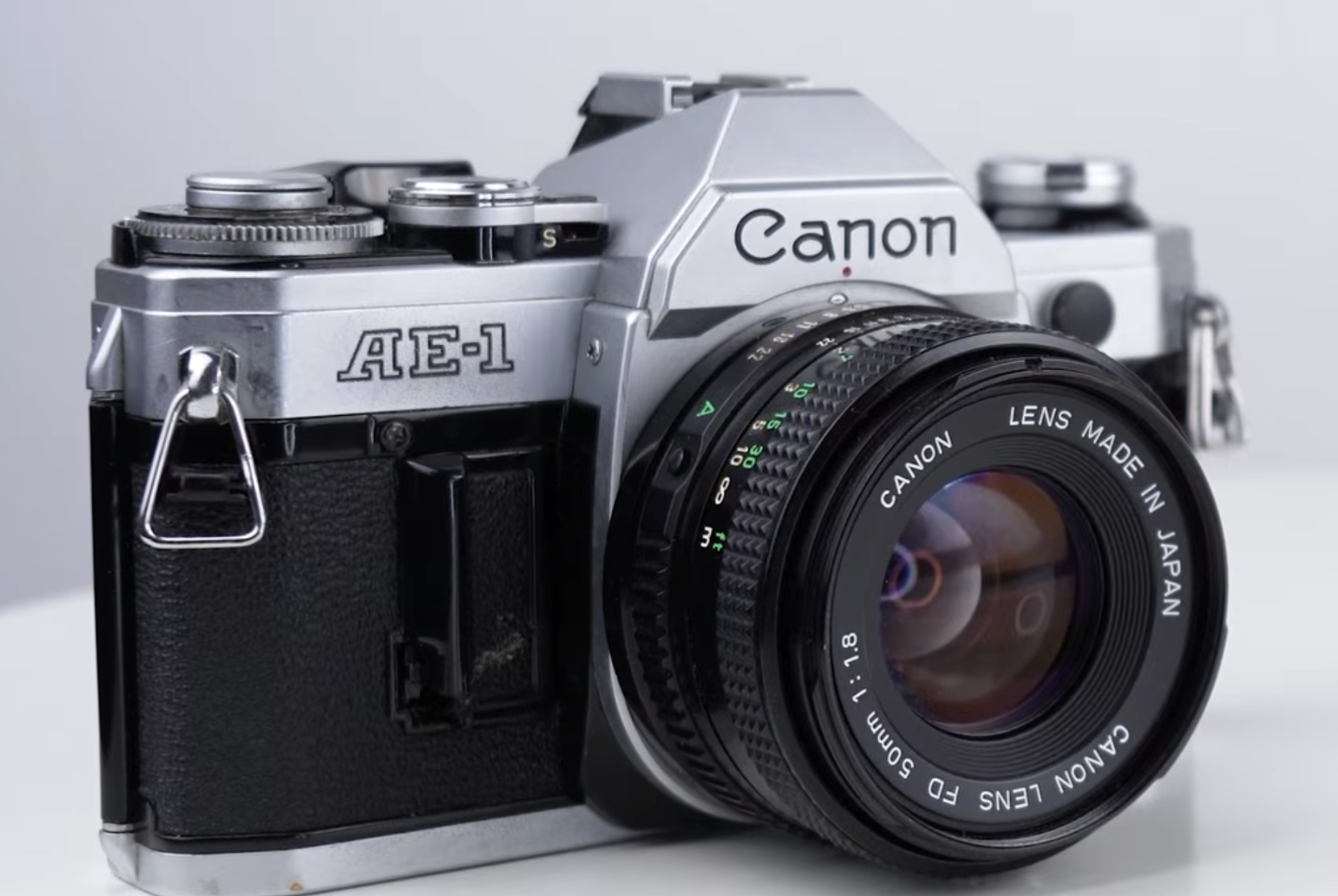 A silver Canon AE-1 35mm film camera with a 50mm f/1.8 lens.