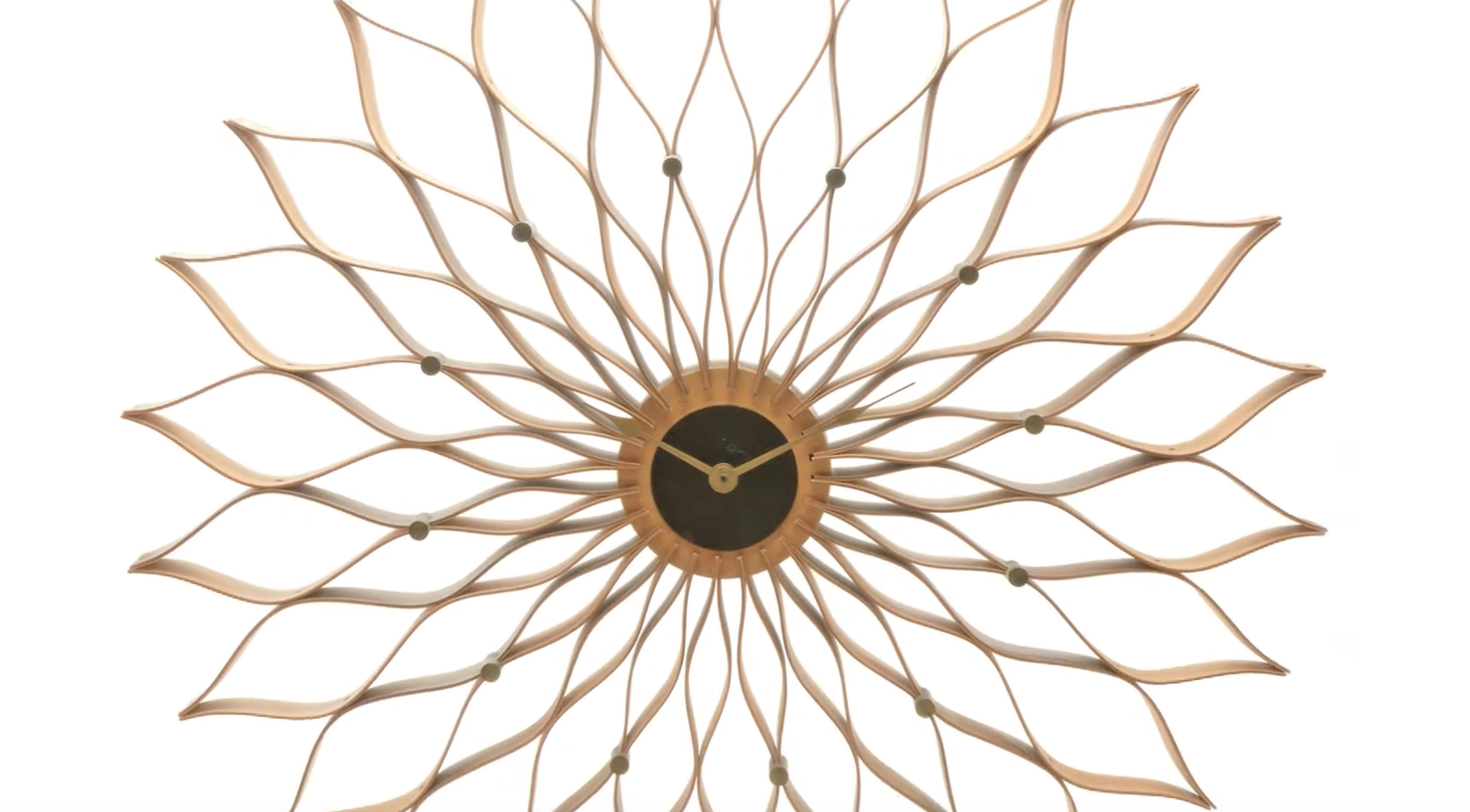 A sunburst-style wall clock with long, curved wooden petals radiating from a dark central dial.