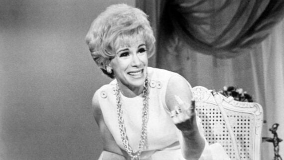 Joan Rivers smiling while gesturing during a television appearance.