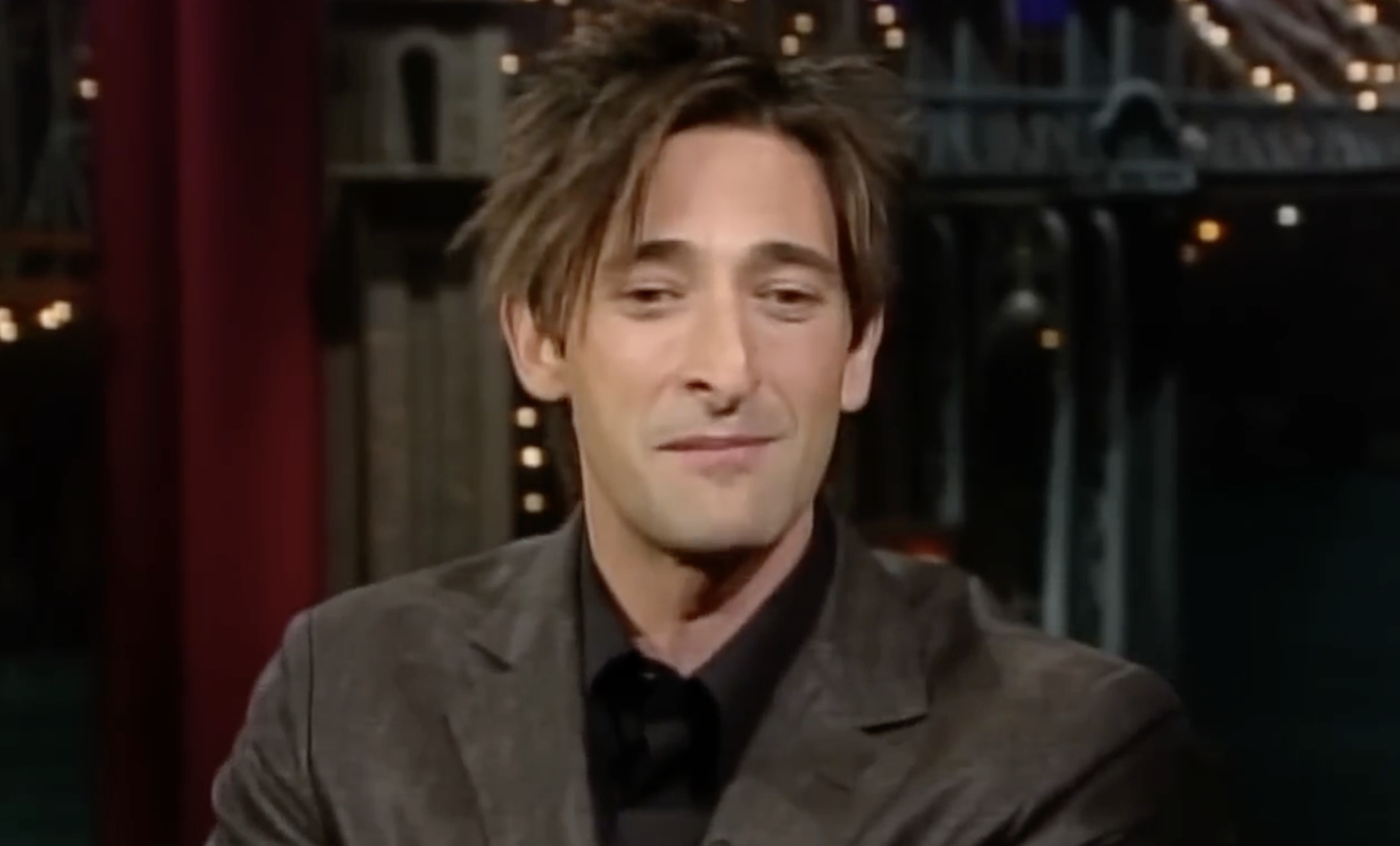 Adrien Brody smiling during a television interview.