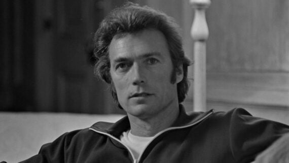 A black-and-white portrait of a young Clint Eastwood looking toward the camera.