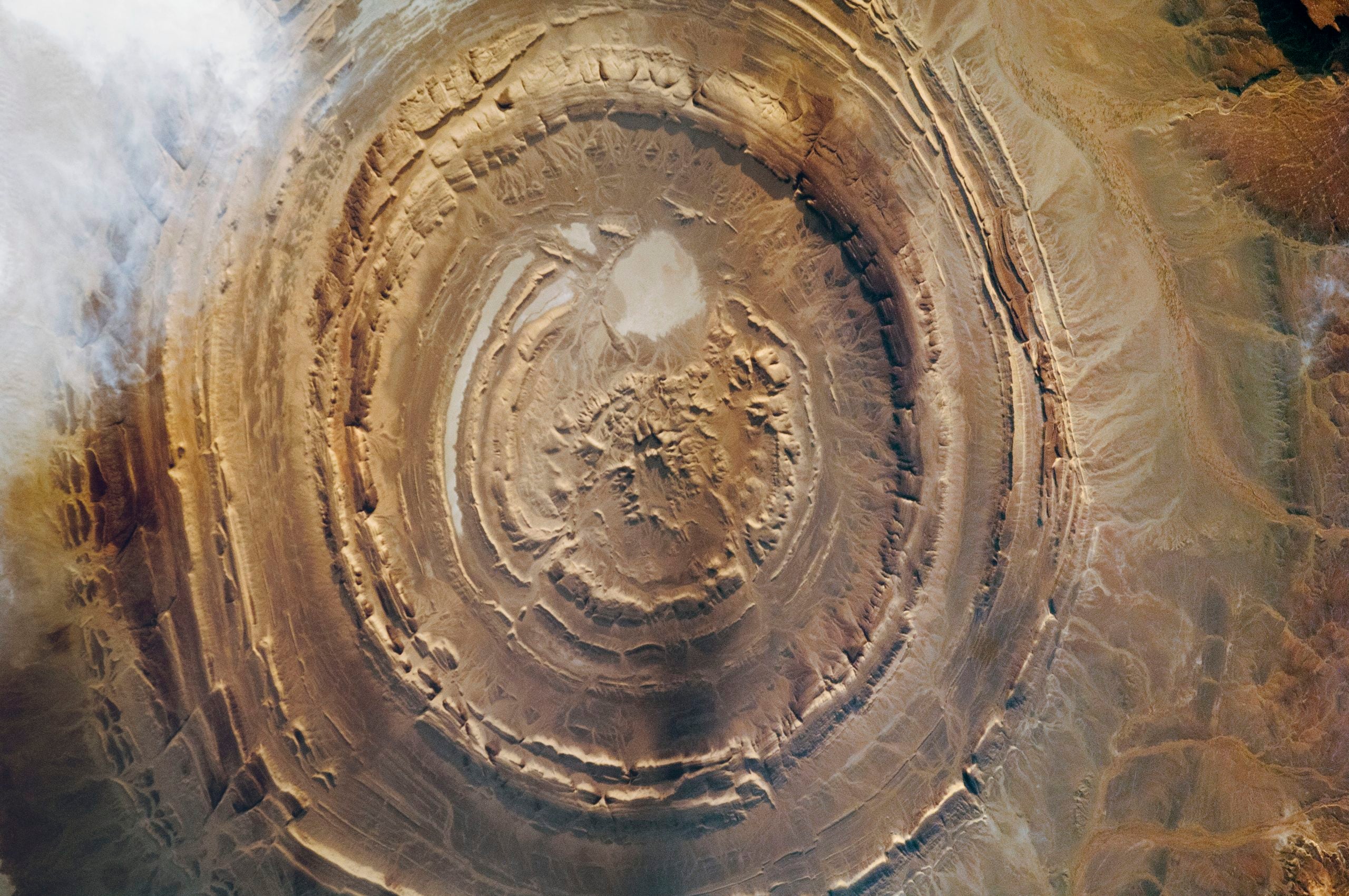 Satellite view of the Richat Structure, a large, circular geological formation in the Sahara Desert resembling a bullseye.