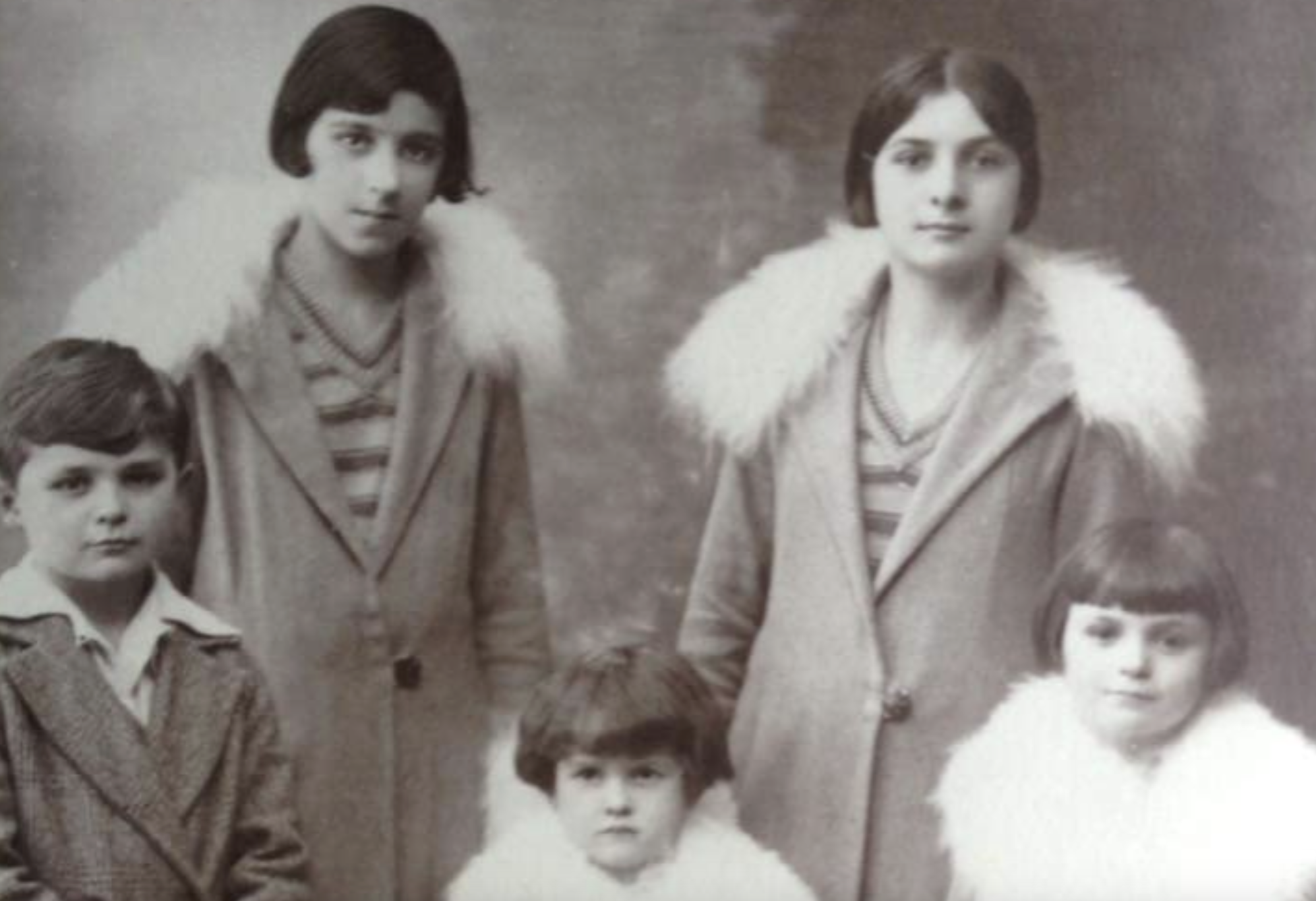 A sepia-toned studio portrait of two young women and two children.