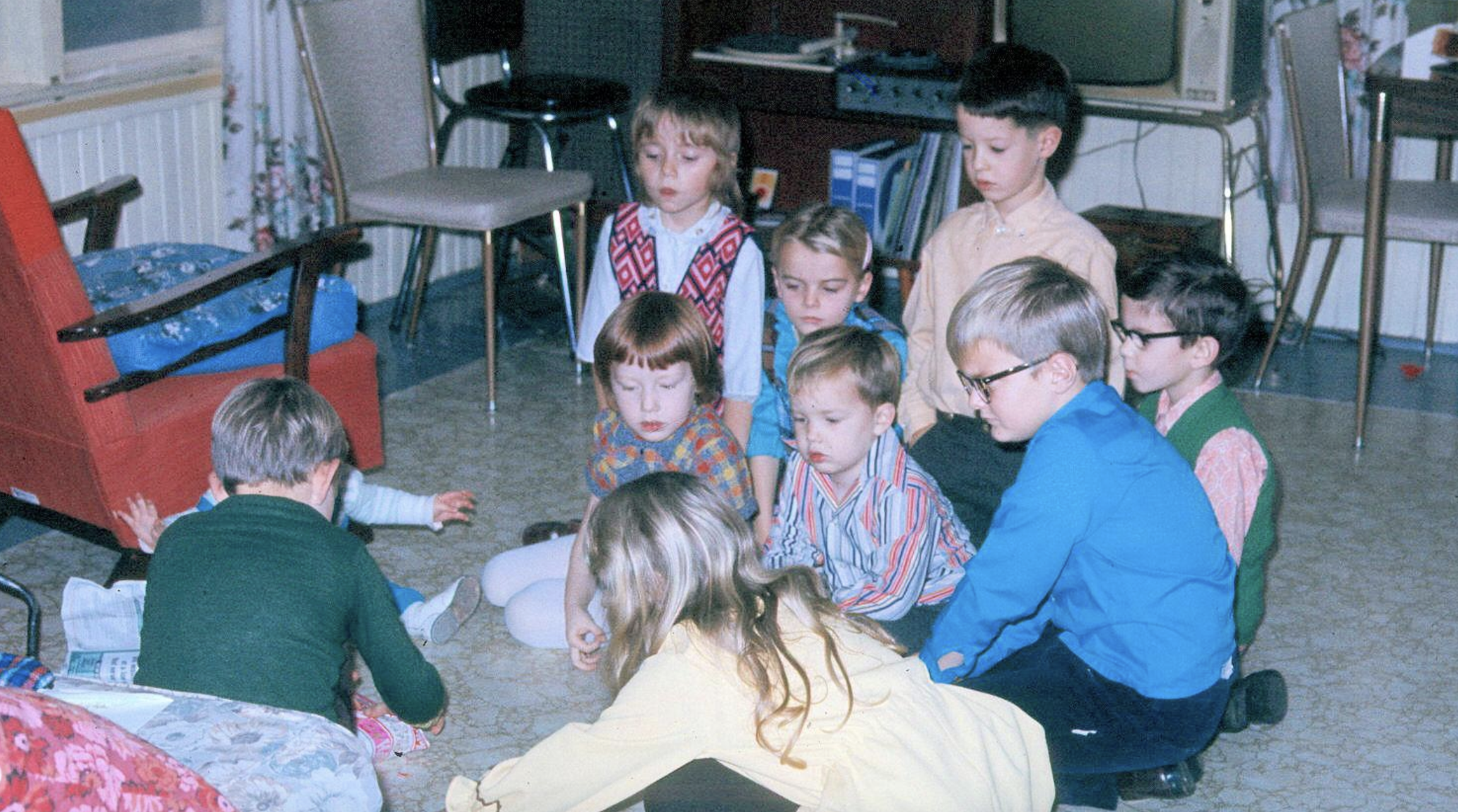 A group of children sitting on the floor in a room, playing together.