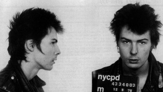 Black and white police mugshot of Sid Vicious, showing both a profile and front view with an NYCPD booking sign.