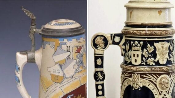 Two ornate ceramic beer steins with detailed relief carvings and hinged metal lids.