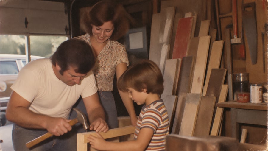 A man, woman, and child building a wooden frame together in a workshop.