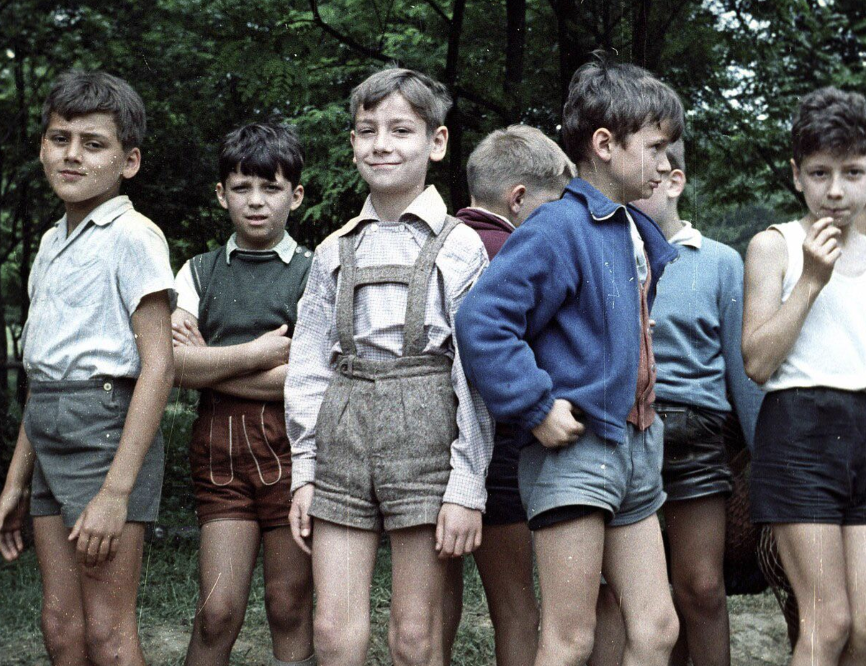 A group of young boys standing in a line outdoors.