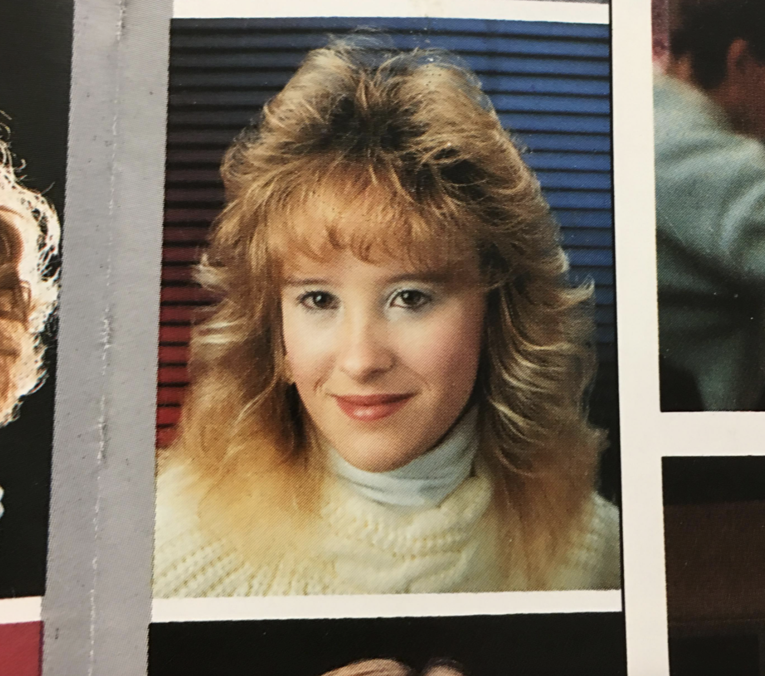 A headshot of a woman with blonde hair wearing a white turtleneck sweater.