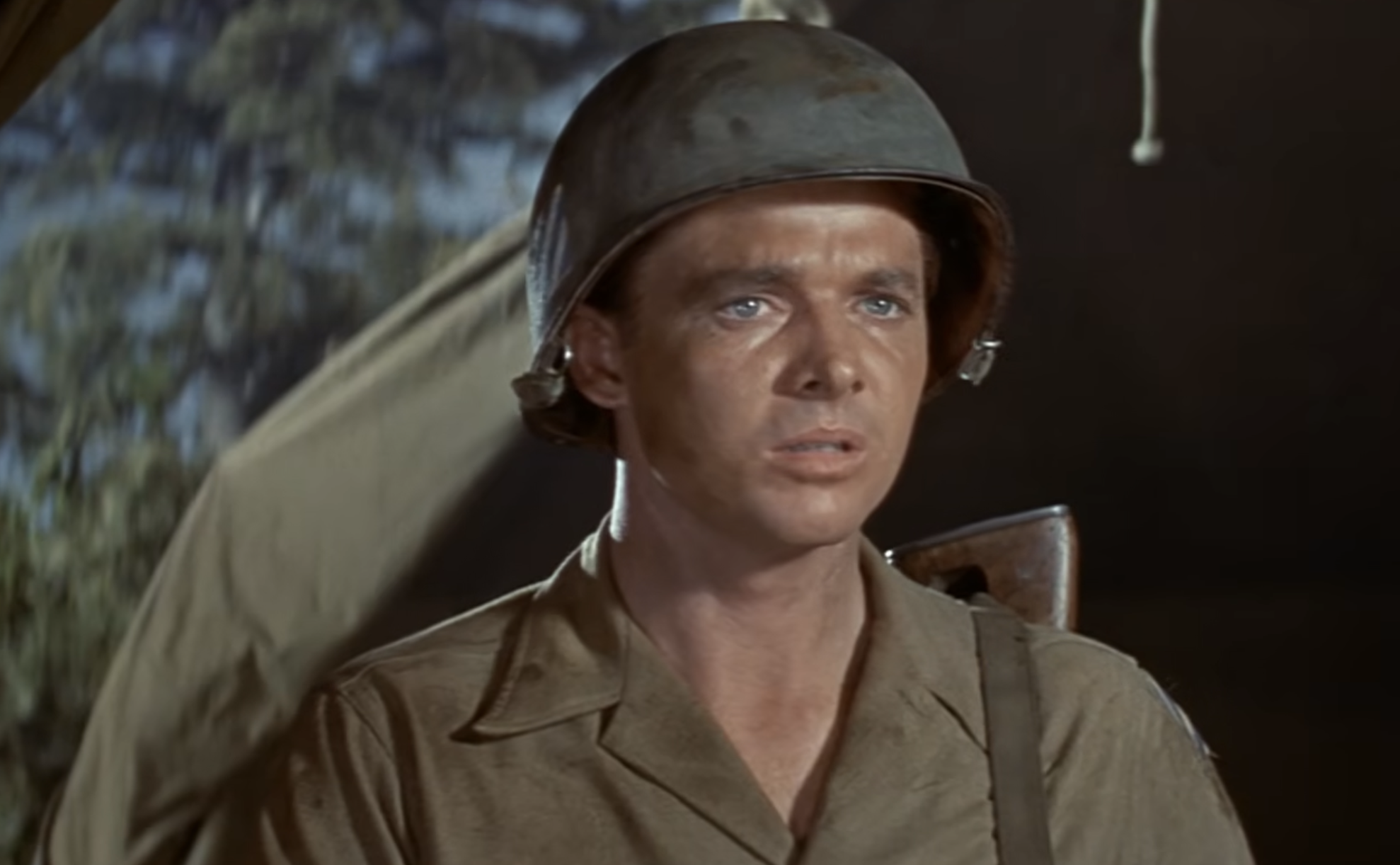 A soldier in a uniform and helmet looking slightly away from the camera.